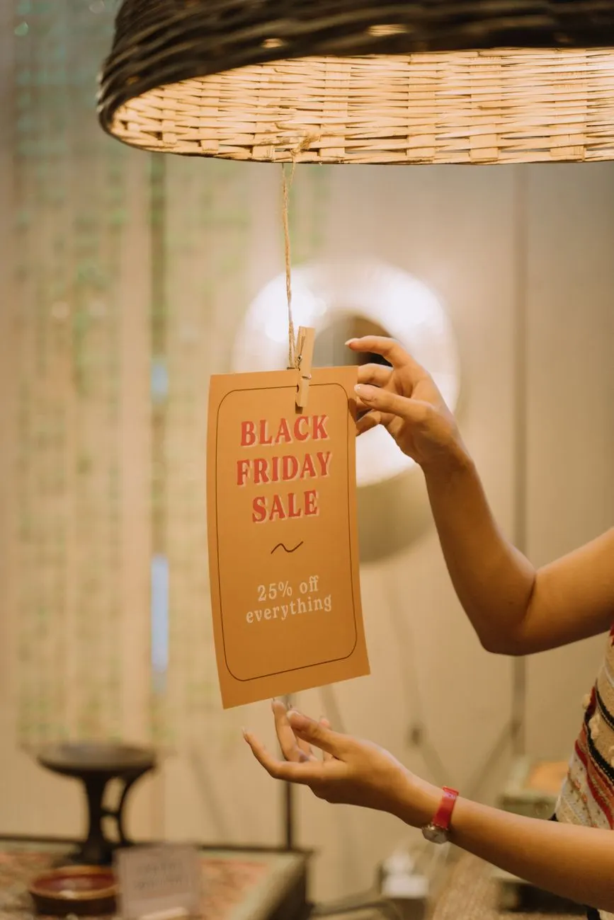 Commerçante accrochant une affiche promotionnelle imprimée dans sa boutique