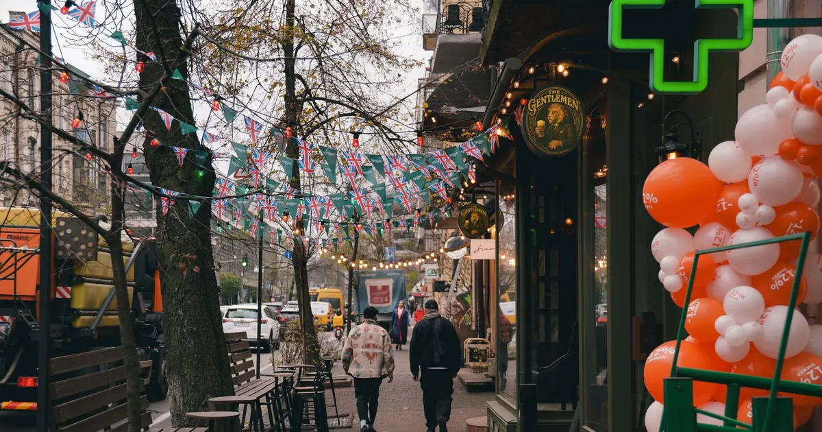 Devanture de commerce vue depuis le trottoir, parmi les enseignes voisines