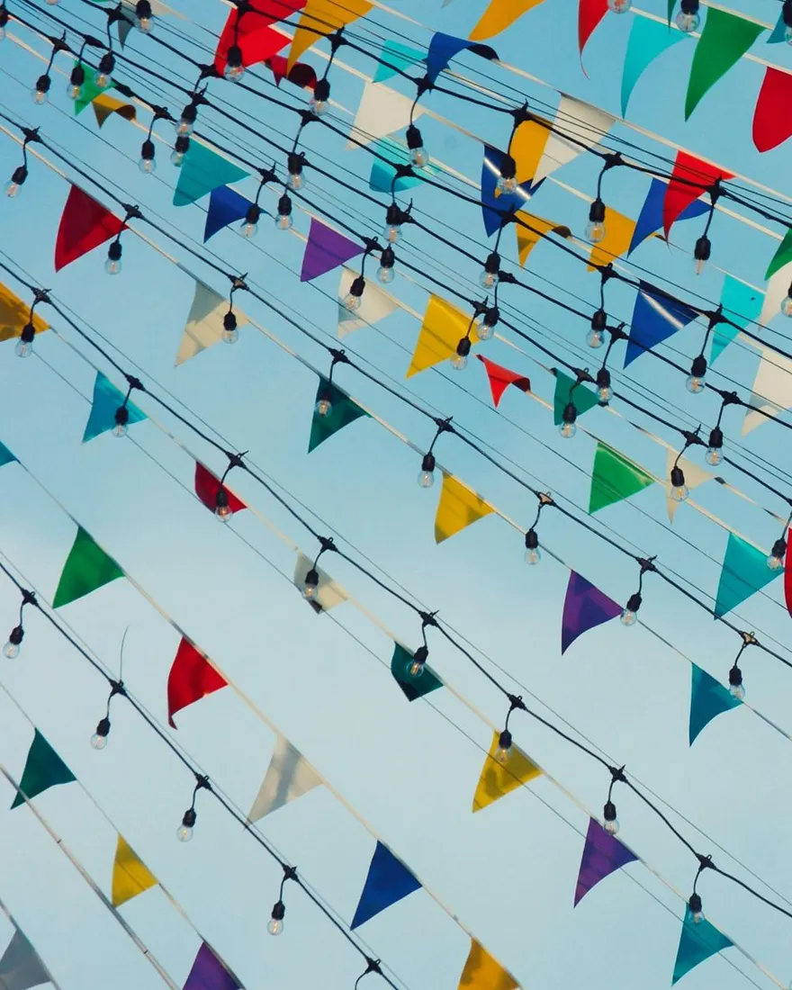 Guirlande de fanions publicitaires colorés au-dessus d'une rue commerçante